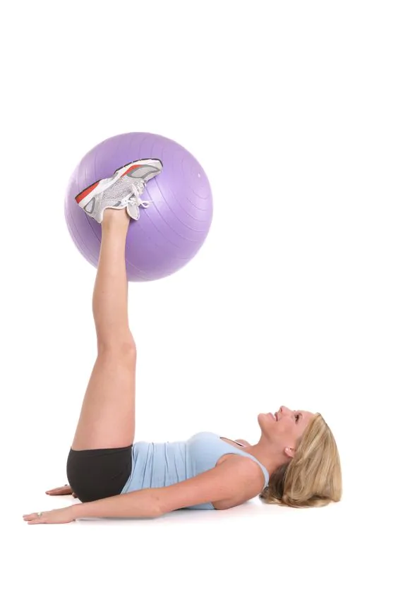 Przekładanie piłki między dłońmi a stopami w leżeniu